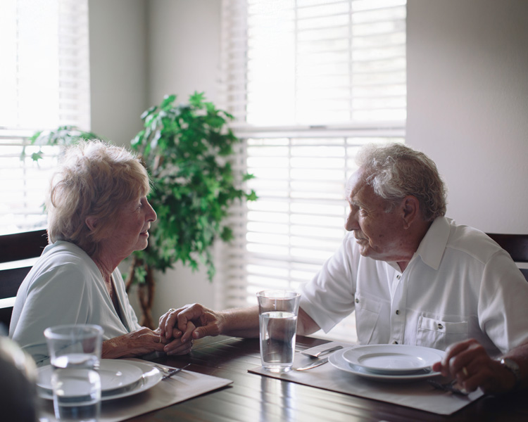 caring senior couple at dinner table